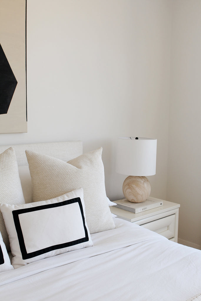 Neutral minimalist bedroom with black and white designer pillows from Arianna Belle | home of Erika Fox of Retro Flame